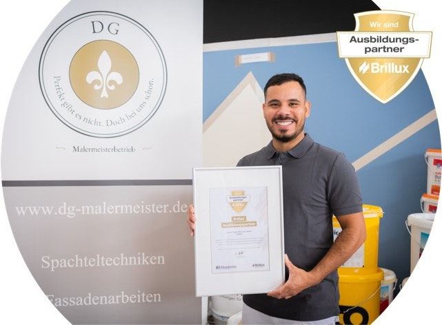 Damian Grade mit der Urkunde als offizieller Brillux Ausbildungspartner